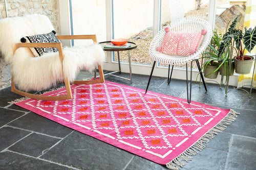 Bright pink rug with cushions