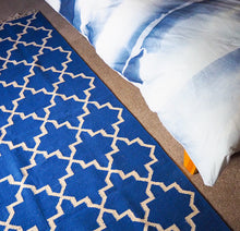 Load image into Gallery viewer, blue and white rug with bed